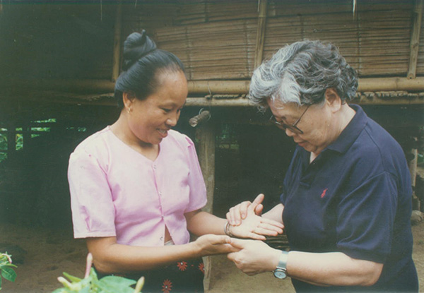 1998年7月，李桓英在云南勐腊县曼南醒村为麻风病愈者检查双手康复情况。.jpg